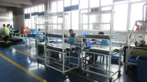 the final assembly production line at SUN-Carts factory where workers assemble electric golf carts on a moving conveyor system