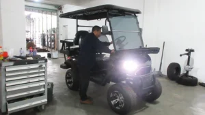 a finished SUN-Carts electric golf cart undergoing final quality inspection at the end of the production line with a technician checking components